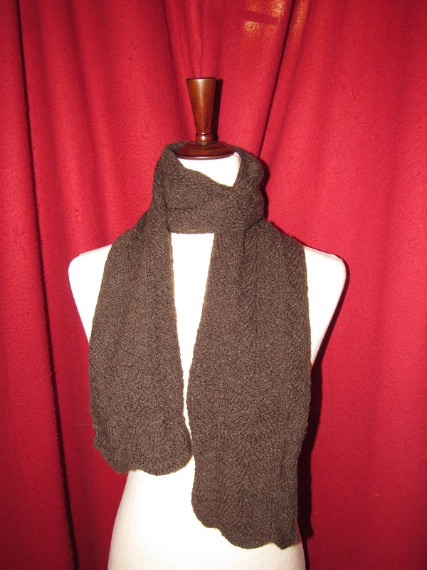 A soft looking brown knit winter scarf with a subtle pattern
