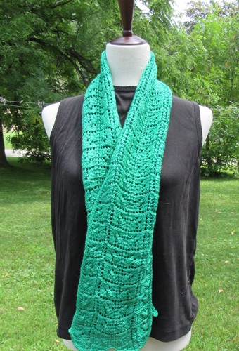 bright green hand knit scarf with a lace leaf motif